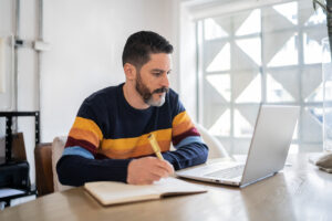 Man takes an online IICRC continuing education course for restoration contractors.
