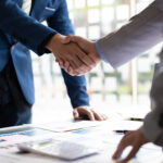 Restoration contractor and state legislator shake hands after discussing insurance legislation.
