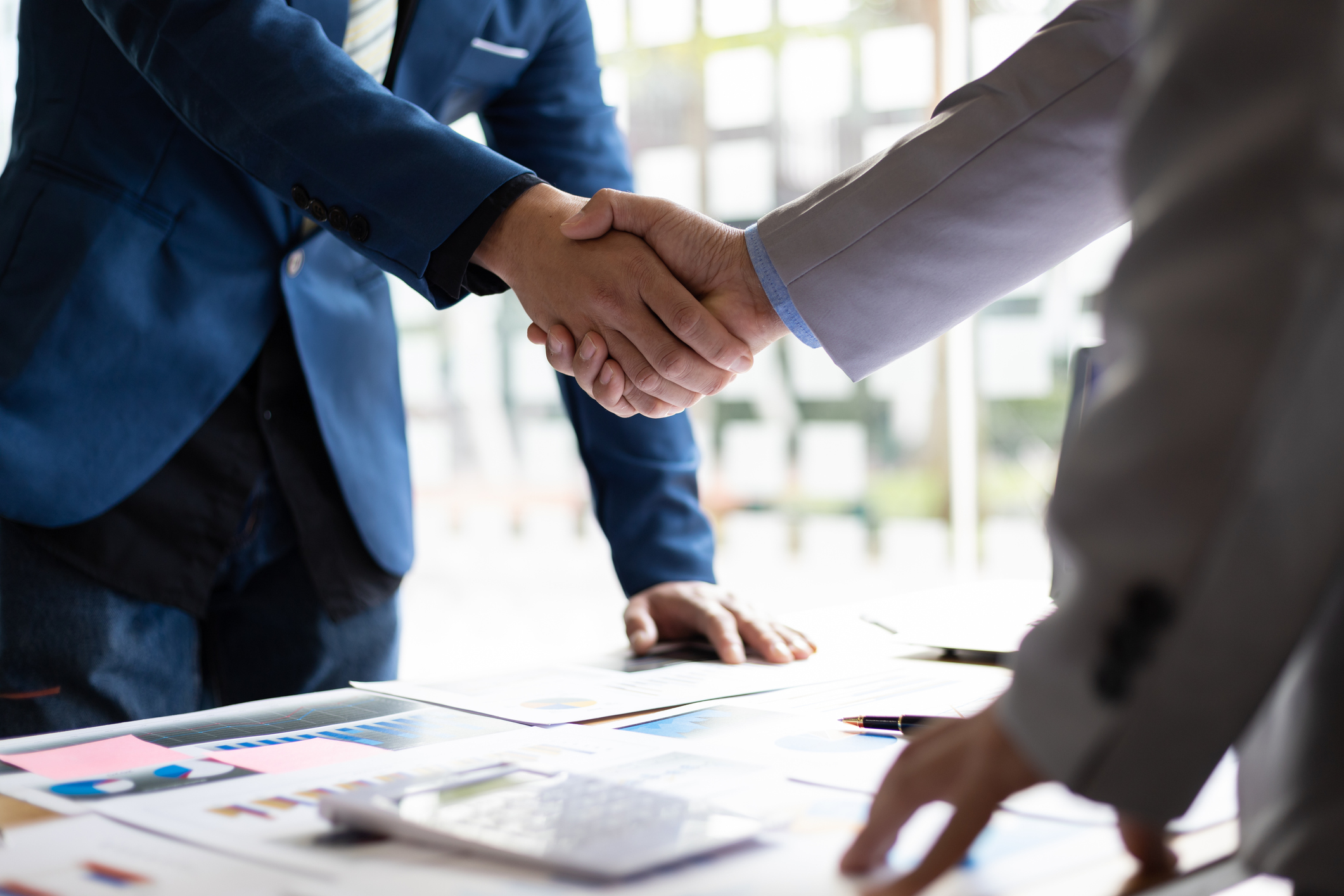 Restoration contractor and state legislator shake hands after discussing insurance legislation.