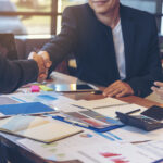 Restoration business owner shakes hand with restoration claims management representative.