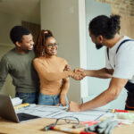 Restoration contractor and restoration customers shake hands after resolving customer concerns.