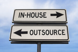 Street signs representing the decision between outsourcing a role or handling it in-house