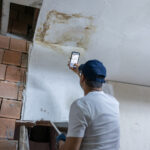 Restoration contractor taking a photo to support a water damage insurance invoice