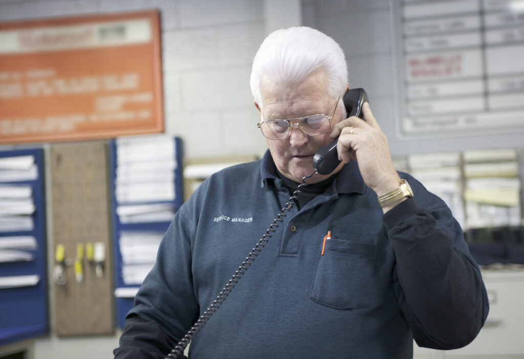 Contractor talks on the phone with a restoration adjuster to negotiate a claim