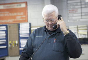 Contractor talks on the phone with a restoration adjuster to negotiate a claim