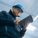 A restoration technician uses restoration claims technology on a tablet while on site.
