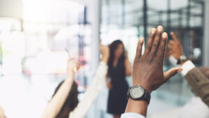 Team members raise their hands during a restoration claims billing training.
