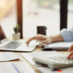 Restoration contractor reviewing slow insurance payment data at desk.