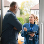 A technician talks about restoration pricing with a homeowner at his front door.