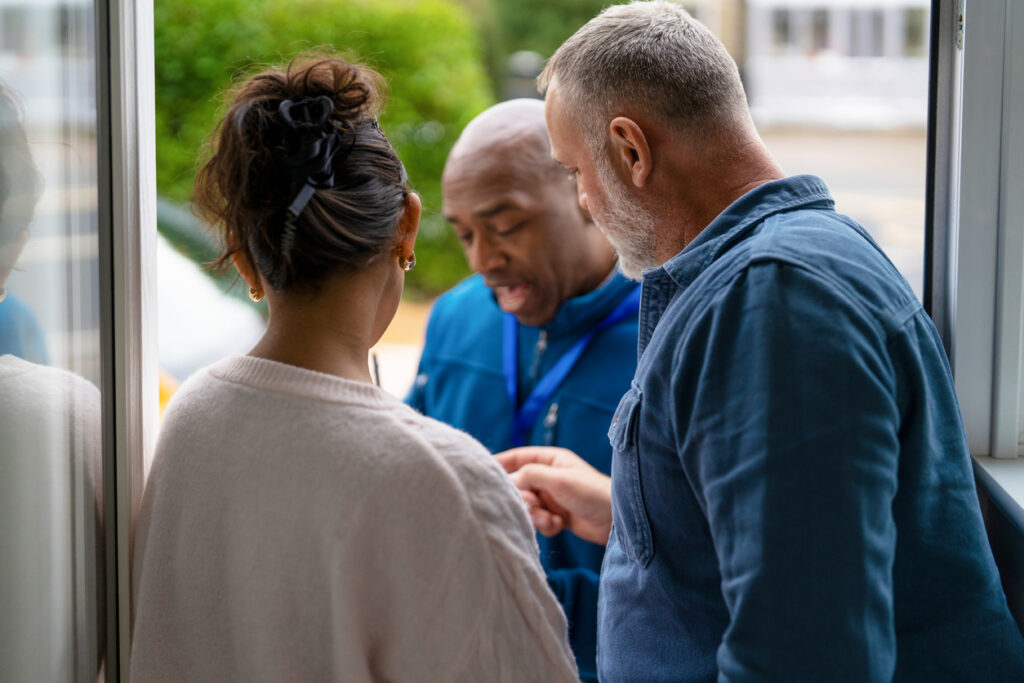 A man and a woman talking with their restoration contractor about restoration pricing