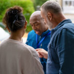 A man and a woman talking with their restoration contractor about restoration pricing