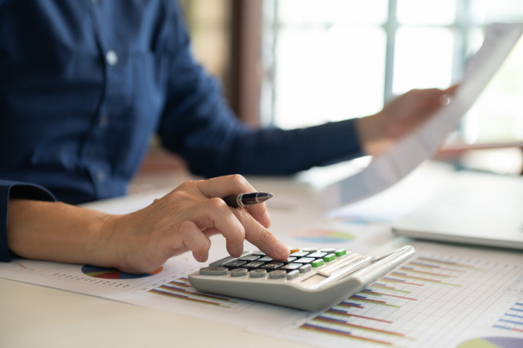 A restoration contractor reviews finances while using a calculator